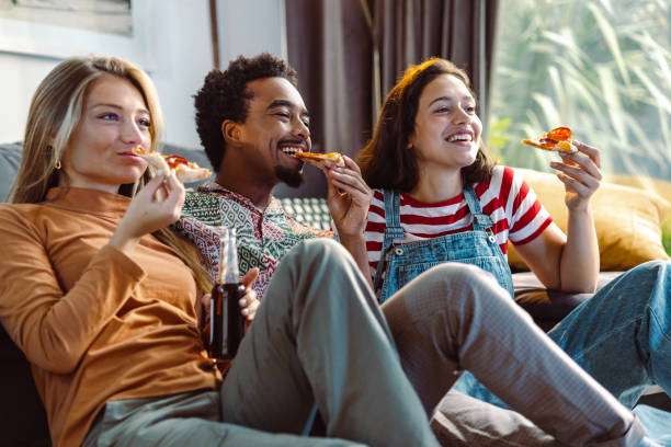 istock Friends hanging out at home and eating pizza 1463735876