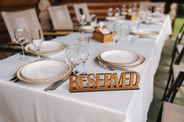 istock Set the table on the terrace with a wooden plate reserved. Table setting, beautiful white plates, silver cutlery and crystal glasses. Outdoor feast on holiday. Party 1463737768