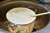 Closeup shot of a dirty cooking pan full of water in a sink