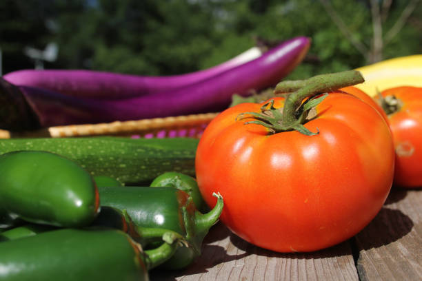 Fresh vegetables, ingredients for a beef stew, on a wooden cutting board.