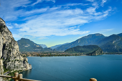 beautiful landscape view from ponale street, Riva del Garda, garda lake,  to cliff, blue sky, mountain peaks, Monte Brione, fence and lake
