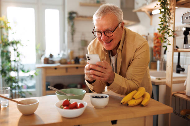 istock Senior man text messaging at his domestic kitchen 1463754189