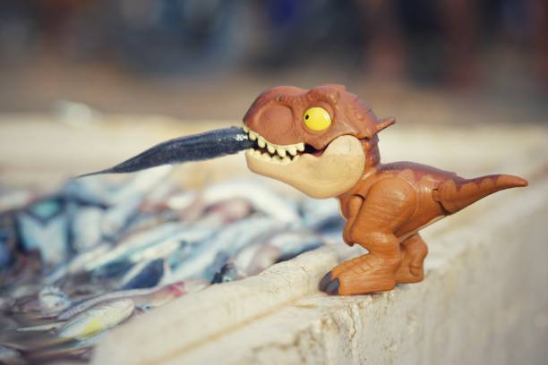 istock Mini dinosaur funny toy with a real fish in the mouth 1463755916