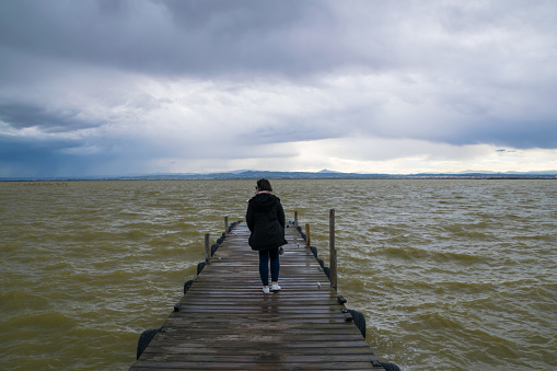 woman walking along the jetty at albufera natural park in Valencia - Spain