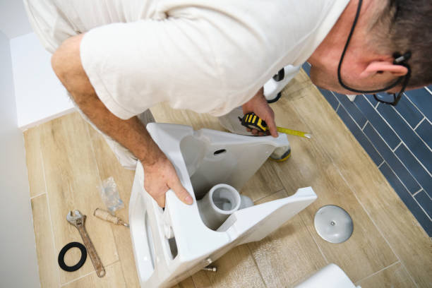 istock Unrecognizable senior plumber installer installing toilet drain flange. 1463756508