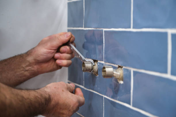 istock Unrecognizable senior plumber installing water tap with a wrench in bathroom. 1463756552