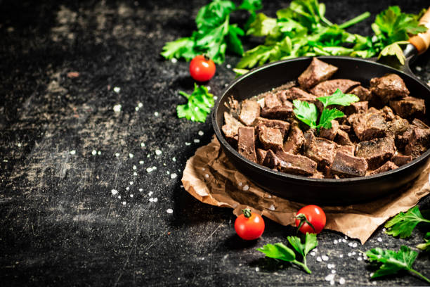 istock Liver cooked in a frying pan with cherry tomatoes and herbs. 1463757348