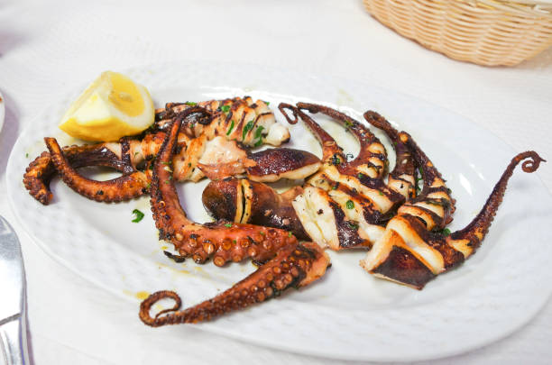 istock Closeup of octopus, a la plancha, served with a lemon 1463758722