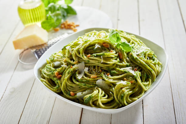istock Portion of delicious pesto pasta with cheese on the kitchen table 1463764855