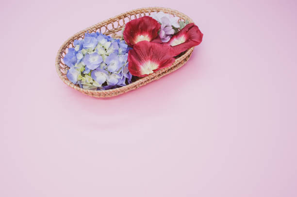 istock Fresh hydrangeas and Shirly poppy flowers on a wicker basket isolated on light pink background 1463765959