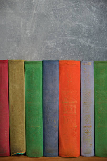 istock Home library of old battered retro books with colored spines. 1463766060