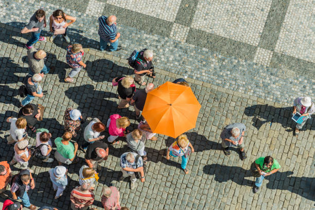Group of tourists is listening to a guide talking in Old Town Square.