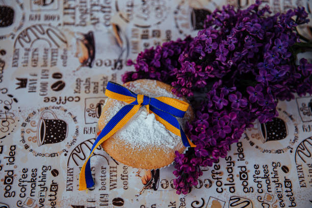 a purple lilac next to a freshly baked cupcake sprinkled with powder