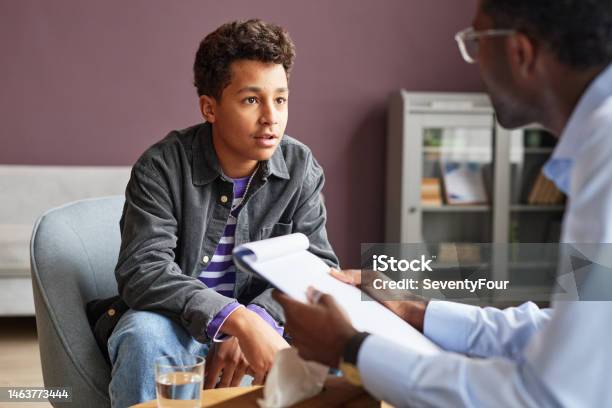 Excited Boy Talking To Psychologist Stock Photo - Download Image Now - Teenager, Mental Health Professional, Psychotherapy