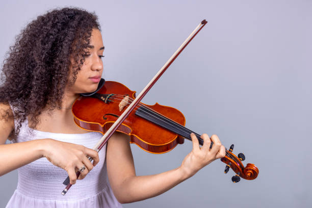 istock Latin violinist playing beautiful melodies on gray background. 1463775741