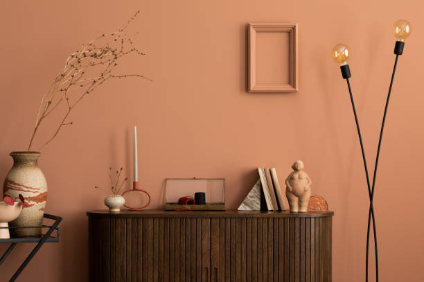 フレーム、木製の箪笥、はしご、ドライフラワーの丸いコーヒーテーブルの花瓶、彫刻、壁の飾り、個人的なアクセサリーを備えた暖かく居心地の良いリビングルームの内部。家の装飾。テ� - showcase interior home decorating chair pink ストックフォトと画像