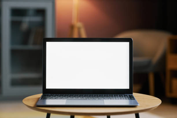 ordinateur portable ouvert avec maquette d’écran blanc dans l’intérieur sombre de la maison - computer business office occupation photos et images de collection