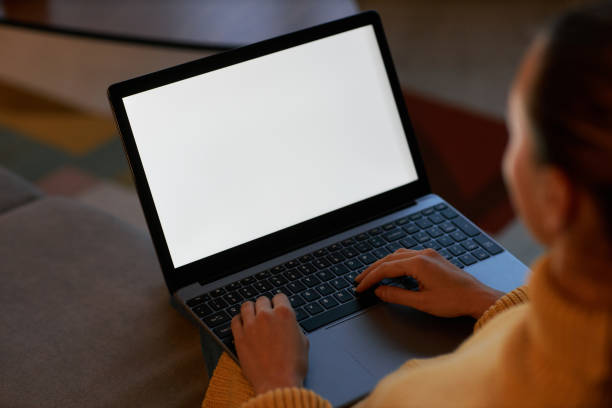 istock closeup young woman using laptop with white screen in dark home setting 1463776422