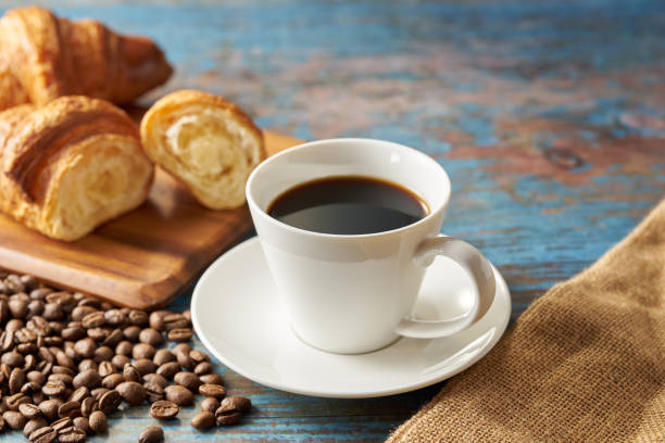 istock Cup of coffee with grains on wooden background 1463776559