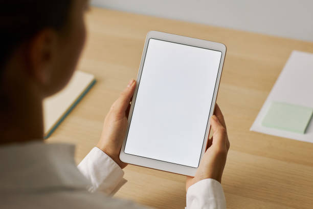 istock Young woman holding digital tablet with white screen mockup at workplace 1463776697