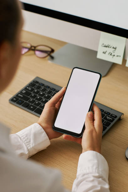 istock Vertical closeup woman holding smartphone with white screen mockup 1463776726