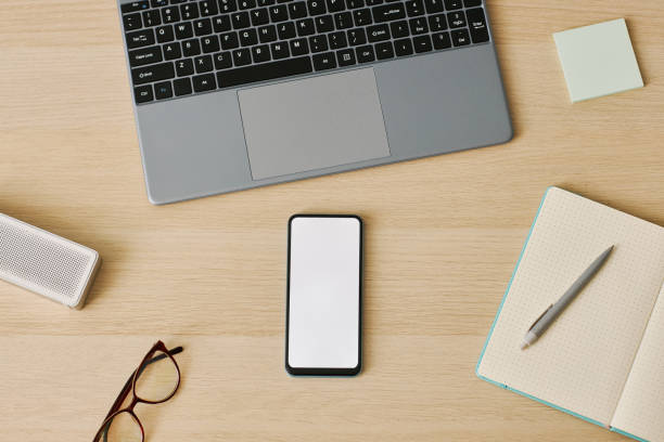 istock Minimal top view smartphone with white screen mockup at desk workplace 1463776913