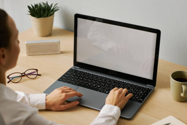 istock Minimal young woman using laptop white screen mockup at desk workplace 1463776949