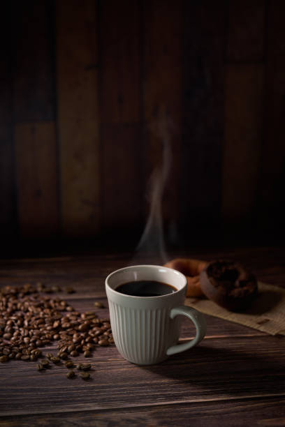 istock Cup of coffee with grains on wooden background 1463776950