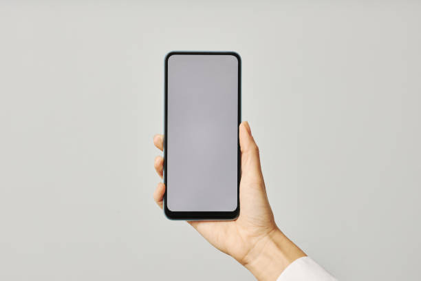 istock Minimalistic closeup female hand holding smartphone with blank screen mock up 1463777560