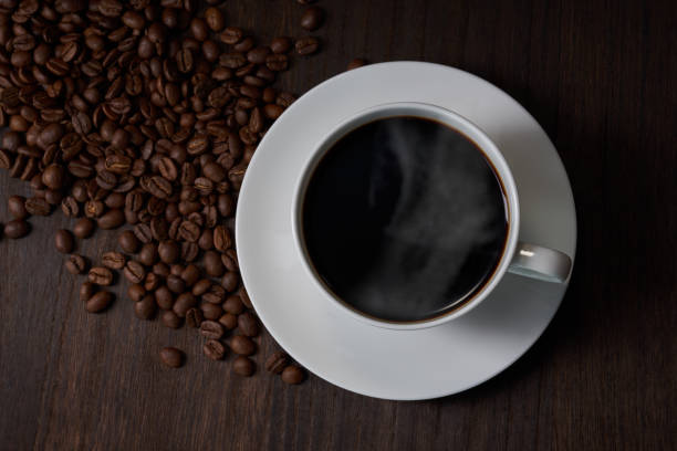 istock Cup of coffee with grains on wooden background 1463777839