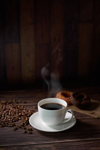 istock Cup of coffee with grains on wooden background 1463778367