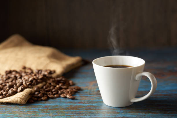 istock Cup of coffee with grains on wooden background 1463779423