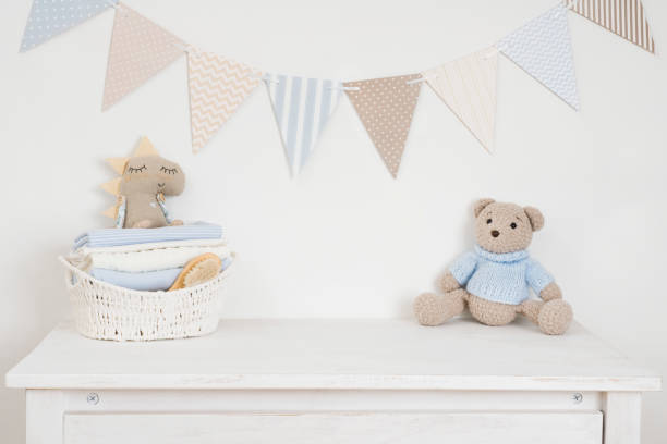 Sideboard with toys and clean baby clothes in children room stock photo