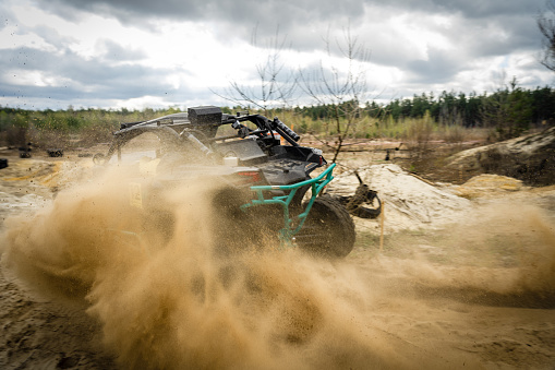 Professional quad biker rides fast on sand. Quad racing, ATV 4x4