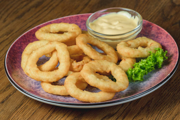 istock Onion rings in a bowl with cheese sauce on the table 1463791013