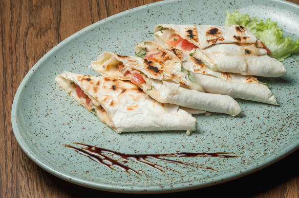 istock Sliced pita bread with meat, vegetables and sauce on a plate 1463791099