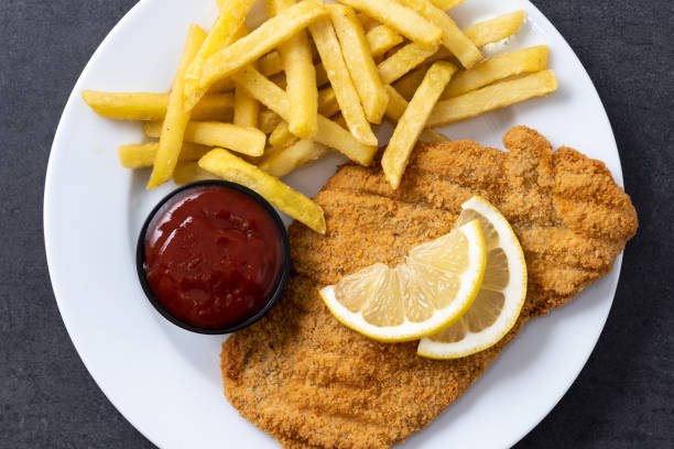 istock Wiener schnitzel with fried potatoes on black background 1463791158