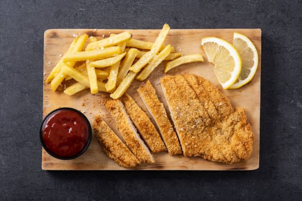 istock Wiener schnitzel with fried potatoes on black background 1463791169
