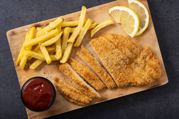 istock Wiener schnitzel with fried potatoes on black background 1463791186