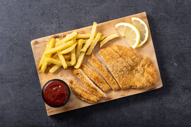 istock Wiener schnitzel with fried potatoes on black background 1463791208