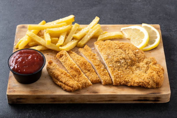 istock Wiener schnitzel with fried potatoes on black background 1463791223