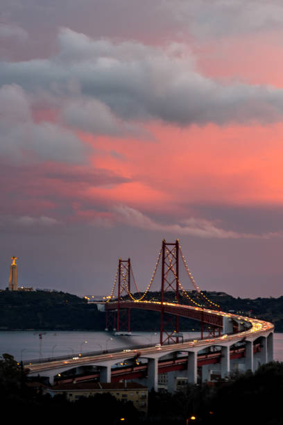 April 25 Bridge in Lisbon at night - long exposure photo with traffic lights on the bridge