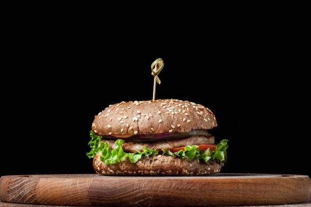 istock burger with a latch on a wooden board on a black background 1463792487