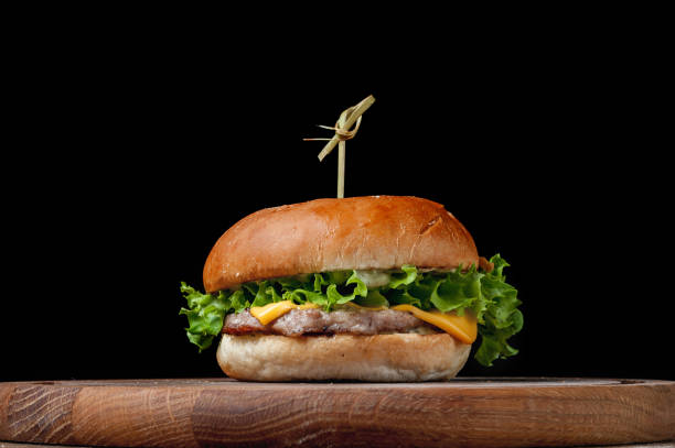istock burger with a latch on a wooden board on a black background 1463792520