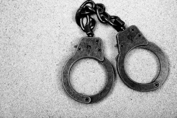 istock image of handcuffs sand background 1463792699