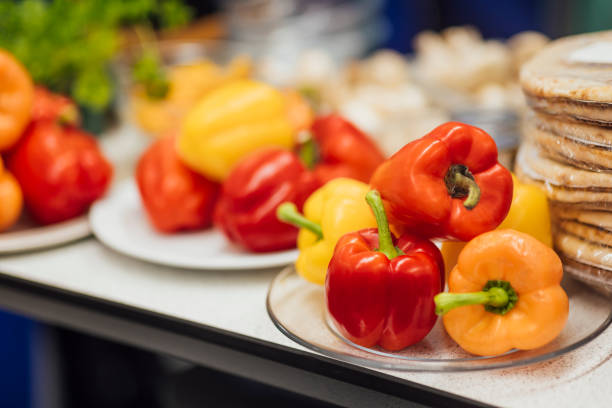 A close up of a plate that has a bell pepper and pizza bases stack din a school home economics class ready for the students to create pizzas in class.