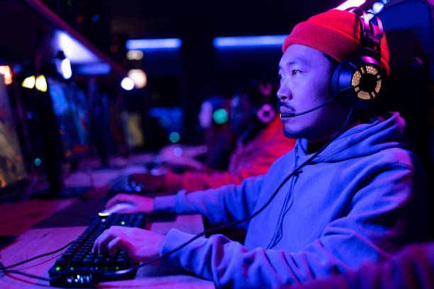 istock Concentrated Asian gamer playing video games on a computer. 1463794381