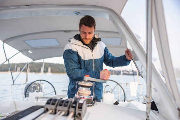 istock Caucasian Sailor Winding Rope Manually With Winch On Sailboat 1463800808