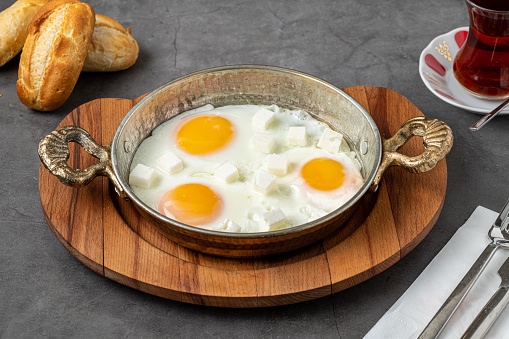 Sunny Side Up Eggs with feta cheese in a copper pan