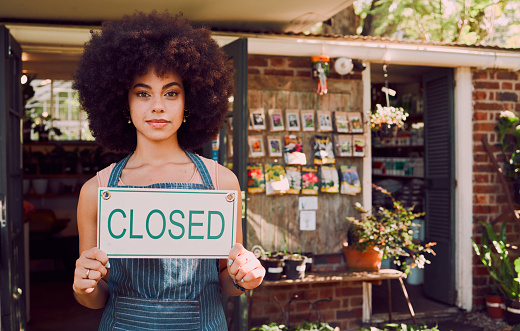 Closed sign, black woman and business owner with smile, happy or content with end of day outdoor. African American girl, female entrepreneur or holding poster for new store, startup company and relax